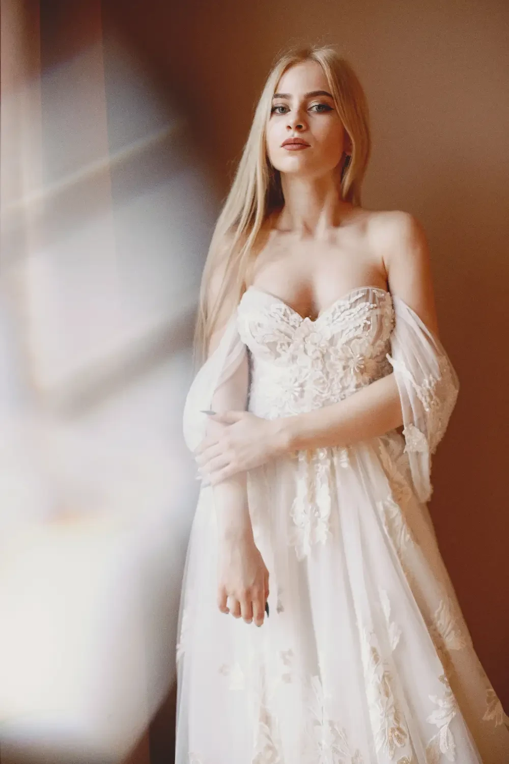 model wears an off the shoulder lace bridal gown