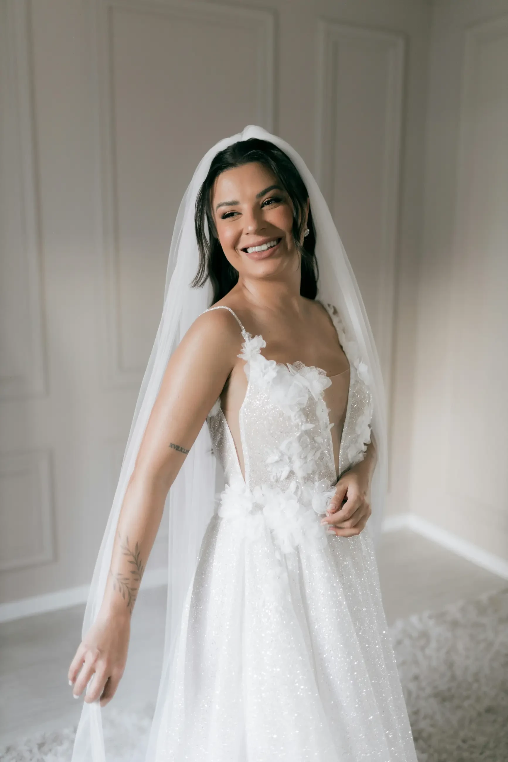 model is wearing a wedding dress and smiling